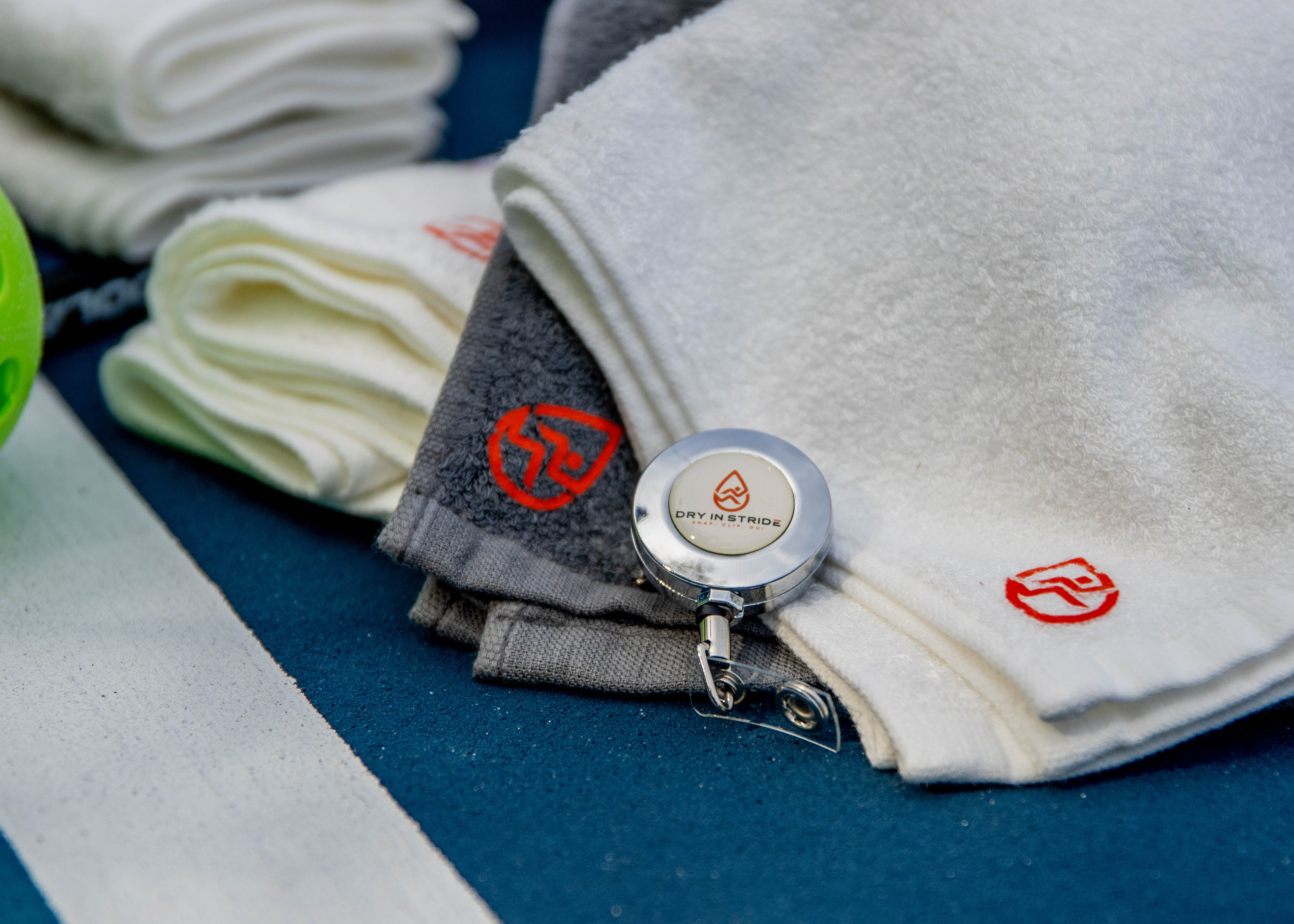 Close up of Dry in Stride towels with clip on pickleball court.  