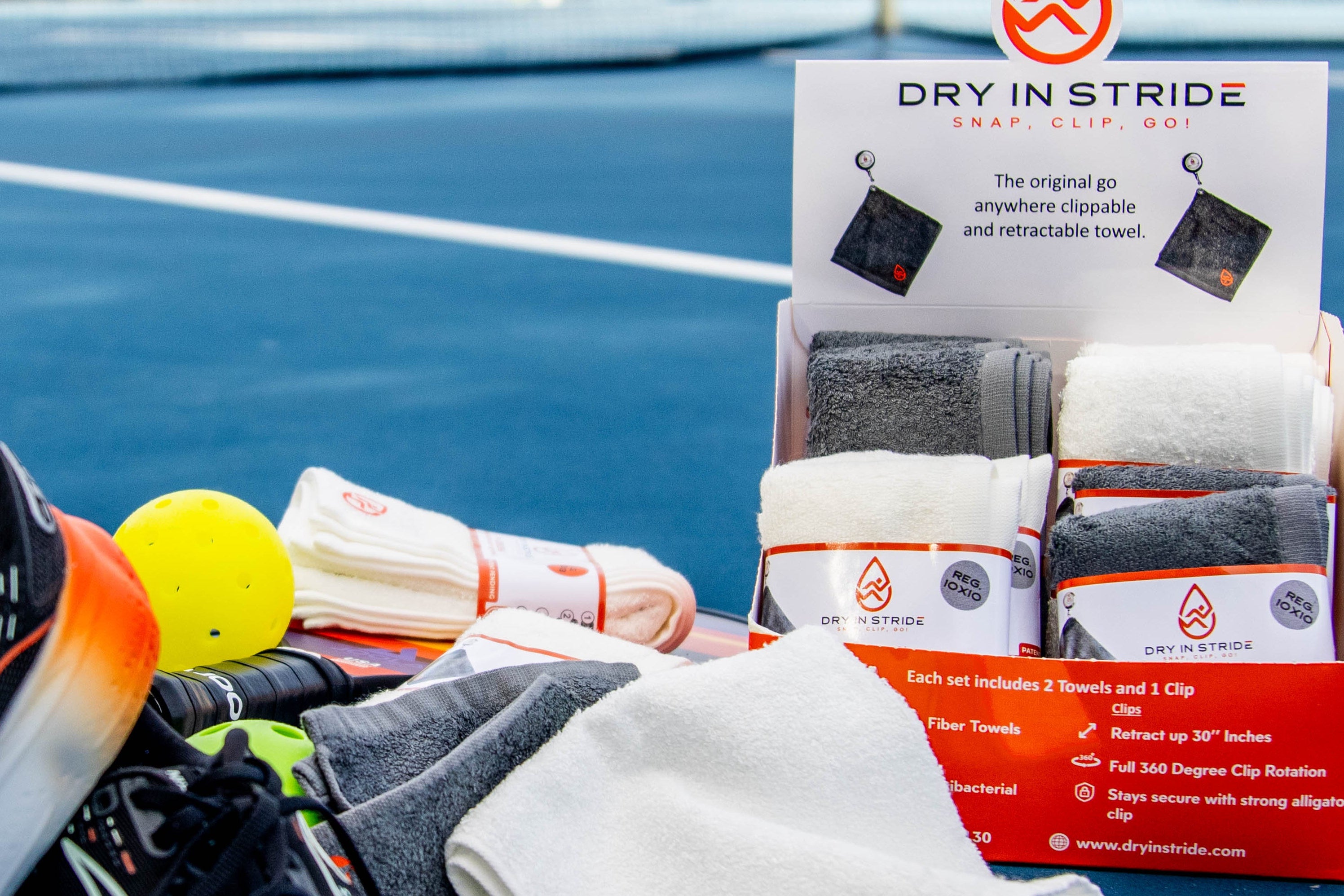 Dry in Stride counter display box towel packaging with towels and accessories on a pickleball court background